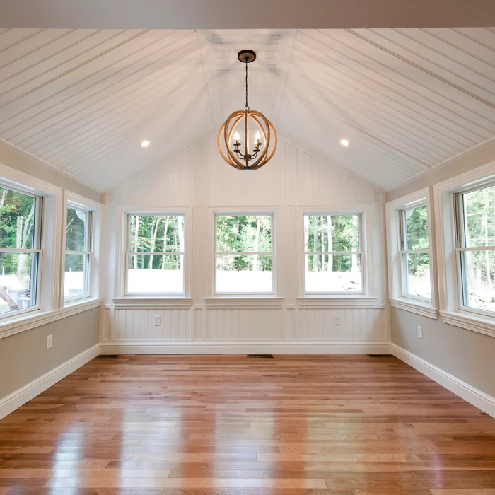 Vaulted sunroom with beadboard ceiling and wood floor