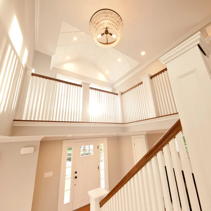 Open staircase and foyer with vaulted ceiling